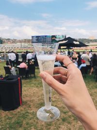 Cropped image of hand holding drink at stadium