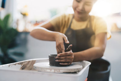 Smiling potter making pottery at home