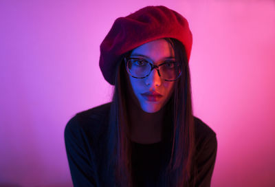 Close-up portrait of young woman against gray background