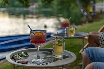People drinking cocktails served on tables in bar by river