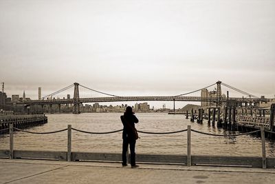 Low angle view of woman walking on bridge