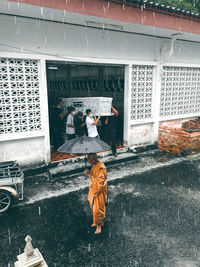 Full length of boy standing on window of building