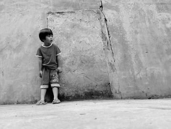 Portrait of boy standing against wall