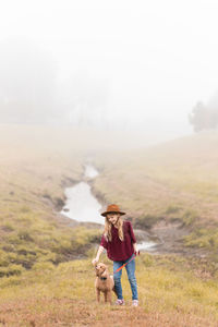 Girl in a foggy field with her dog 