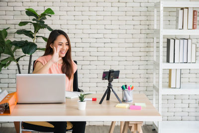 Happy businesswoman gesturing on video call at desk