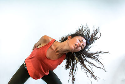 Woman with tousled hair against sky