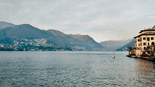 Scenic view of sea by buildings against sky