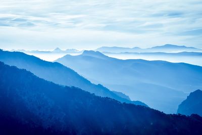 Scenic view of mountains against blue sky