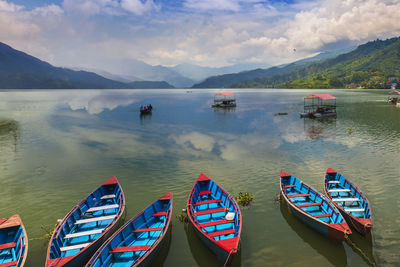 Boats moored in lake against sky