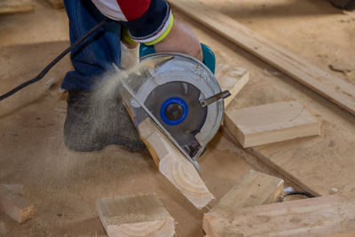 Low section of man standing on wood