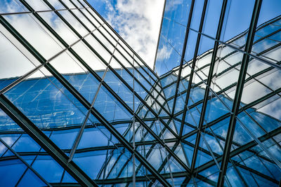 Low angle view of glass building against sky