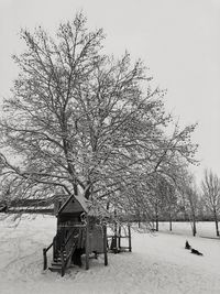 Built structure on snow covered field against sky