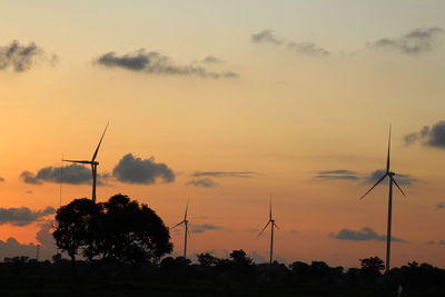 Silhouette of wind turbine against sky during sunset