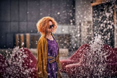 Woman with umbrella standing in rain