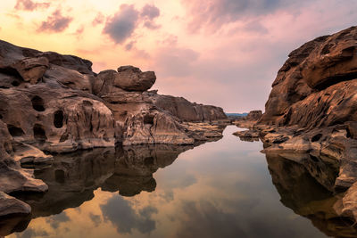 Reflection of rock formations in water at sunset