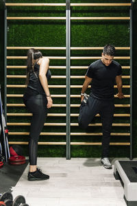 Couple stretching in the gym in the espalier