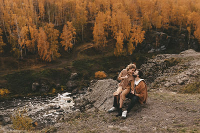 Woman sitting on land by trees