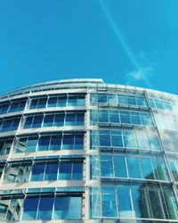 Low angle view of office building against blue sky