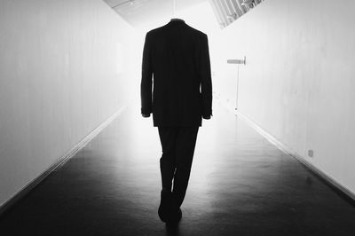 Rear view of man walking in corridor