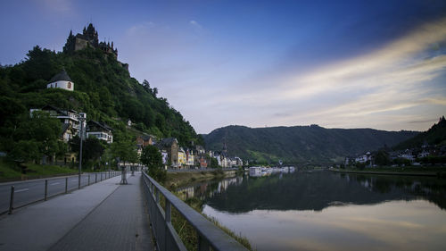 Road by buildings against sky in city