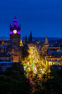 Illuminated buildings in city against sky