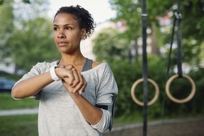 Woman using smart watch while looking away at park