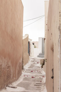 Narrow alley amidst buildings against clear sky