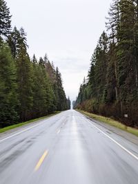 Road amidst trees against clear sky