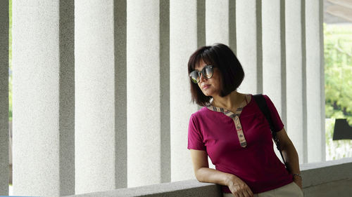 Portrait of woman standing against wall