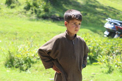 A cute kashmiri boy in his traditional dress in pine woods