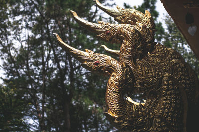 Low angle view of statue of tree against plants