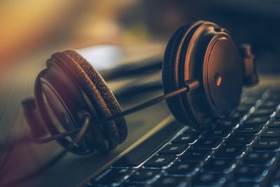 Close-up of headphones on computer keyboard