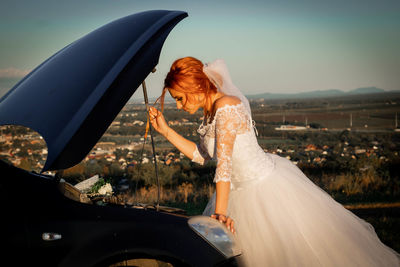 The bride checks the oil level in the engine