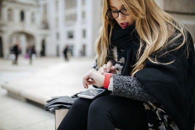 Young woman outdoors checking her smartwatch