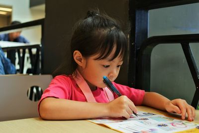 Close-up of girl sitting on table