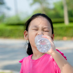 Girl with eyes closed drinking water