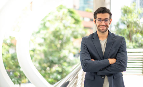 The portrait of a happy young handsome caucasian businessman with eyeglasses and suits.