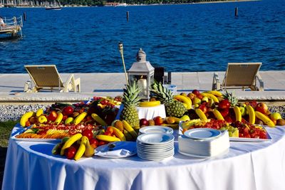 Various fruits on table by sea