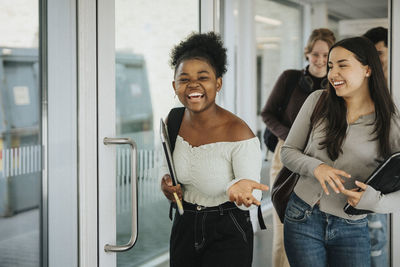 Cheerful multiracial students entering classroom in university