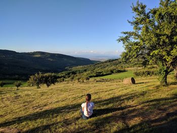 Man looking at field against sky