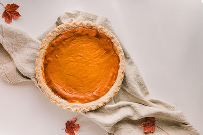 Traditional fall season pumpkin pie on the white table, top view. autumn food