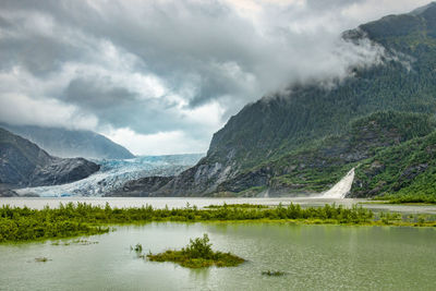 Scenic view of lake and mountains against sky