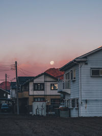 Houses and buildings against sky at sunset