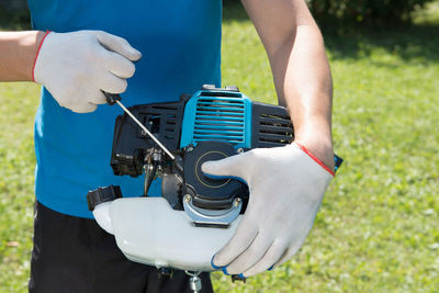 The man cutting a grass with the lawn mower. closeup