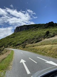 Road leading towards mountain against sky