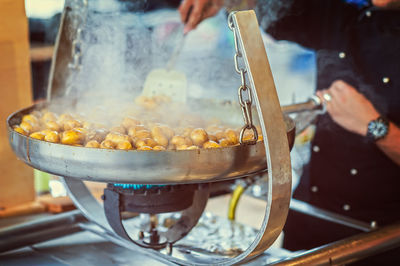 Cropped hands of man preparing food on stove