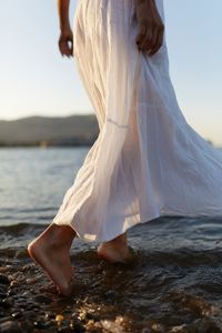 Low section of woman standing on beach