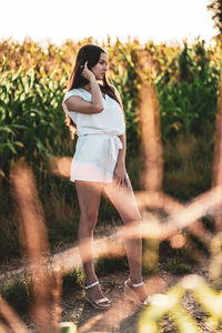 Young beautiful woman with brown hair in the corn field.