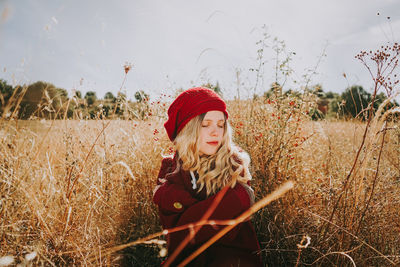 Beautiful woman with eyes closed sitting amidst plants