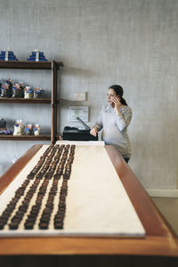 Woman talking on mobile phone while standing at store